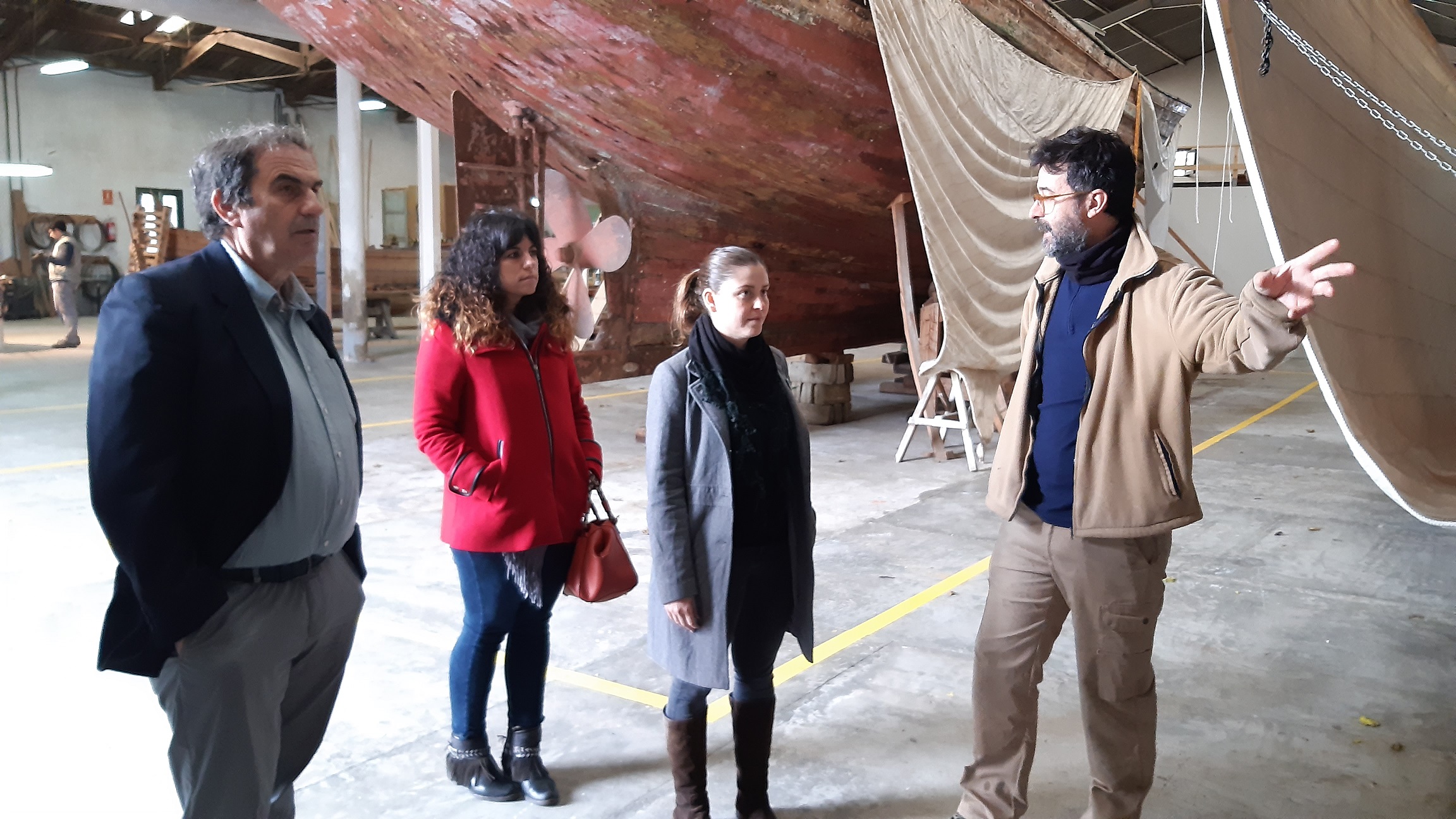 Josep Manchado, Mercedes Moragón i Aurora Ribot escoltant a en Josep Florit, responsable del taller.