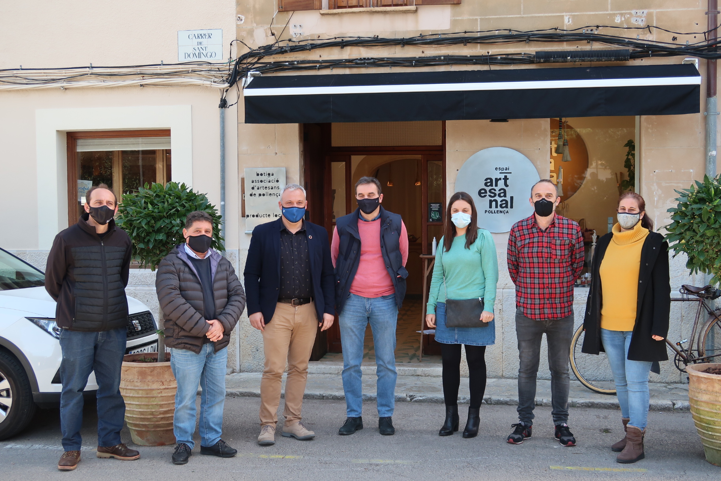 El conseller de Promoció Econòmica i Desenvolupament Local, Jaume Alzamora, el batle de Pollença, Bartomeu Cifre, i la directora de Comerç i Artesania, Marta Jordà, amb representants del consistori i de l'Associació d'Artesans de Pollença.