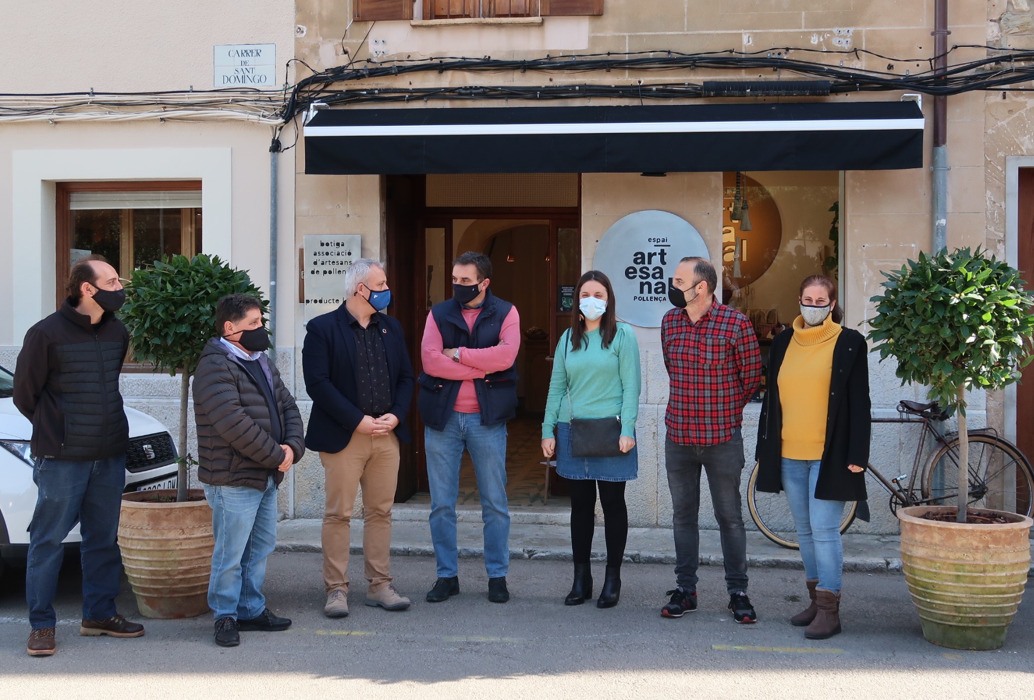 El conseller de Promoció Econòmica i Desenvolupament Local, Jaume Alzamora, el batle de Pollença, Bartomeu Cifre, i la directora de Comerç i Artesania, Marta Jordà, amb representants del consistori i de l'Associació d'Artesans de Pollença.