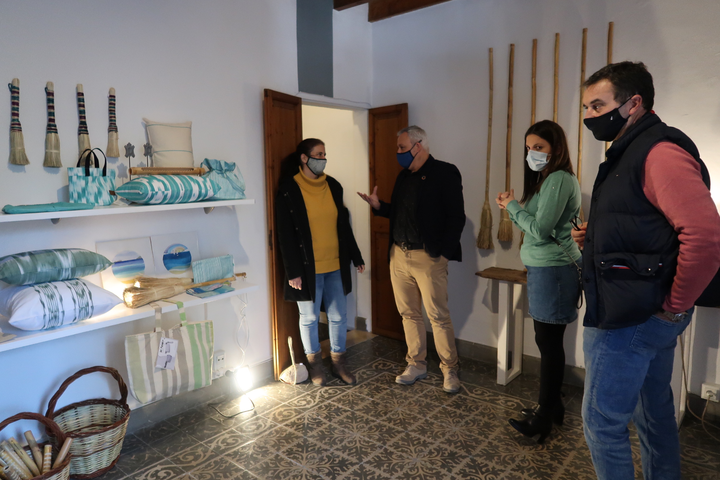 El conseller de Promoció Econòmica i Desenvolupament Local, Jaume Alzamora, el batle de Pollença, Bartomeu Cifre, i la directora de Comerç i Artesania, Marta Jordà, amb Anabel Ferrer, de l'Associació d'Artesans de Pollença.
