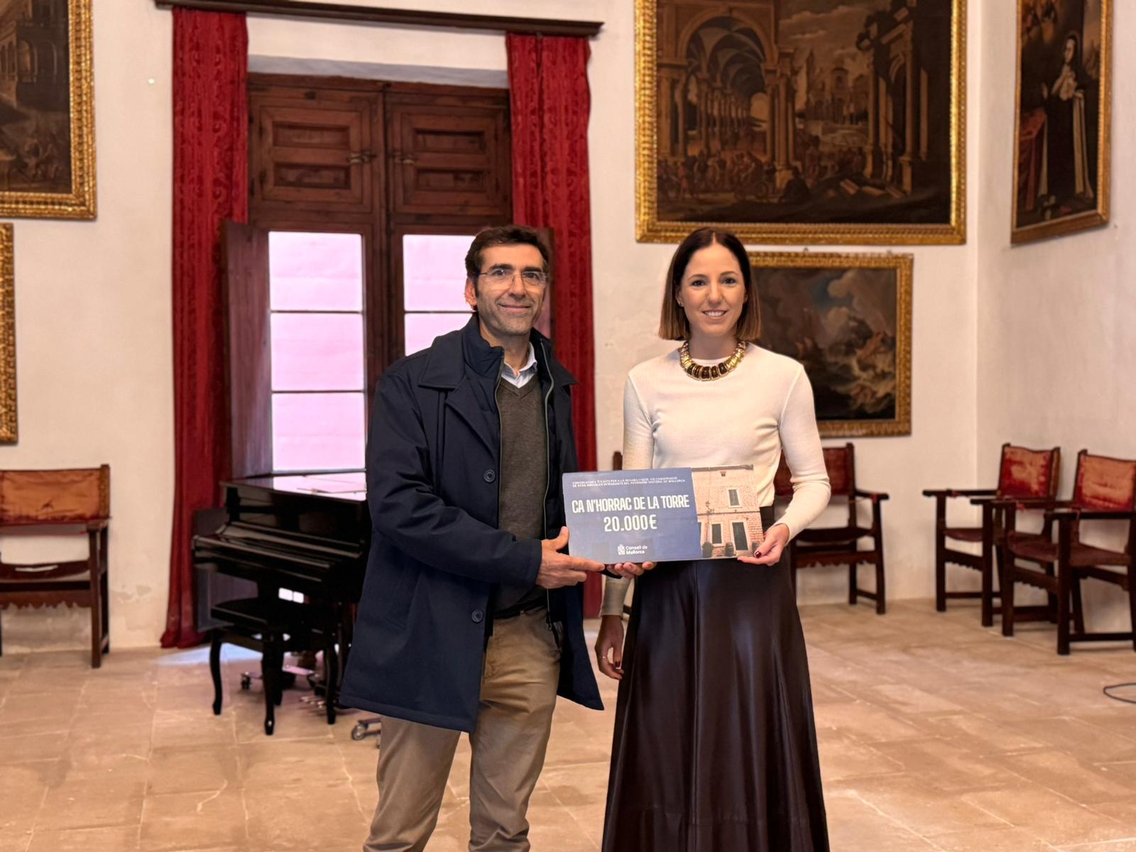 La consellera de Cultura i Patrimoni, Antònia Roca, lliura la subvenció al representant de Ca n'Horrac de la Torre.