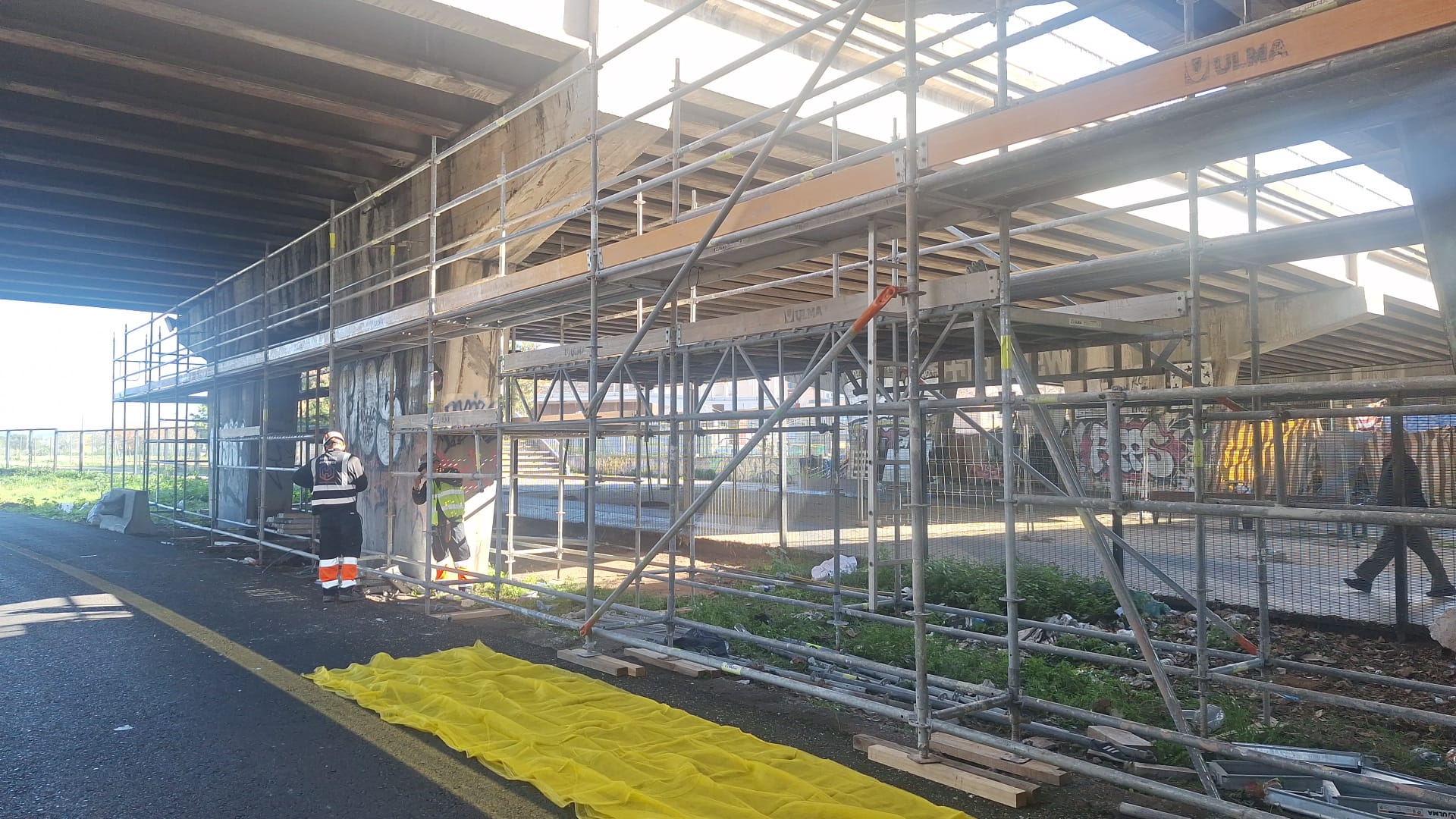 Operararios instalando los andamios para poder acomenter las obras de reparación en el punete de Jacient Verdaguer.