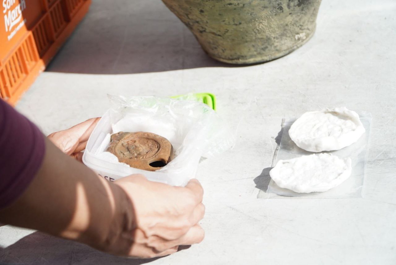 Detalle de la lucecilla de aceite con la imagen de la diosa Diana y del negativo extraído del crismó localizados en el derelicto de ses Fontanelles.
