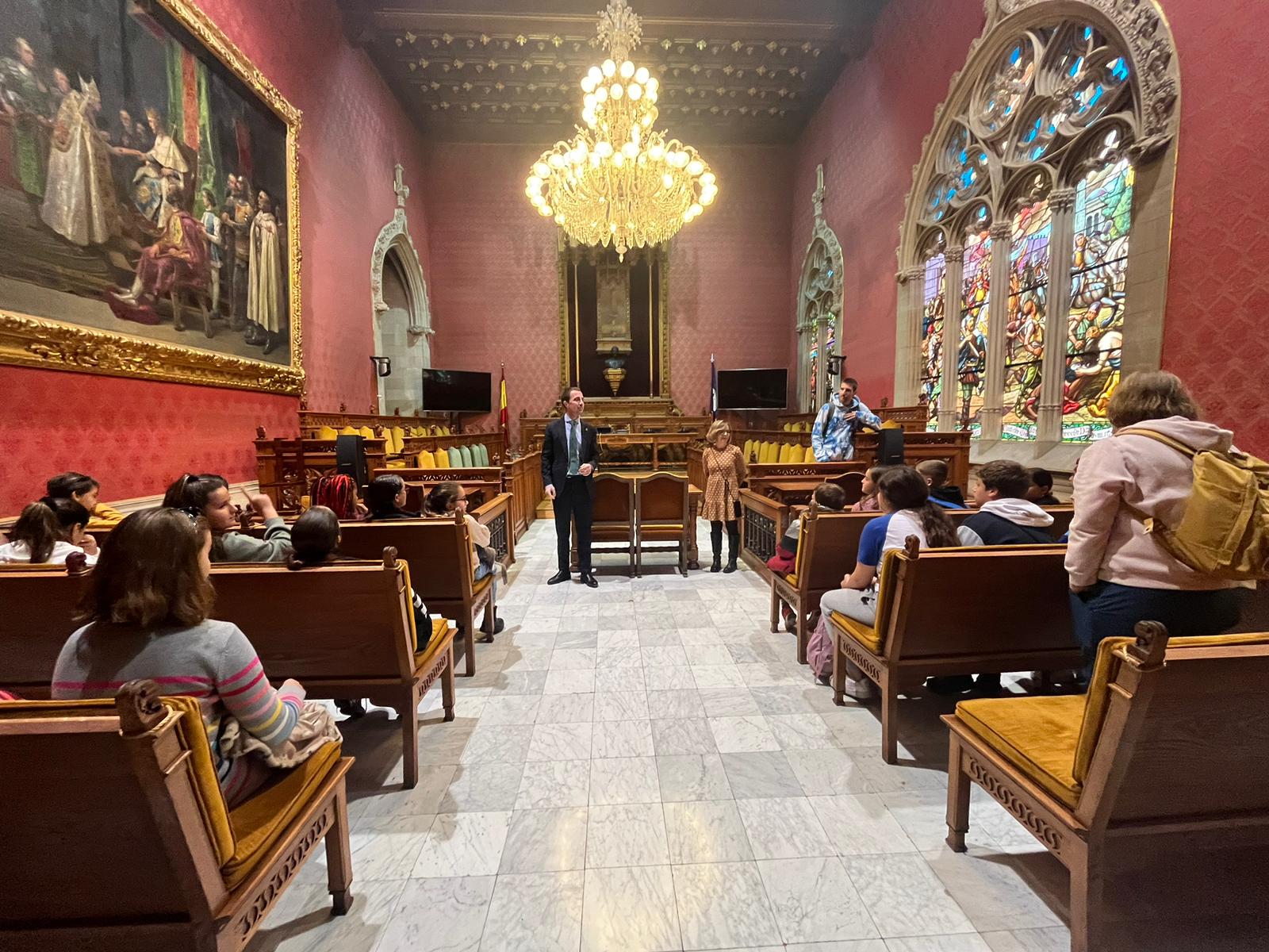 Visita d'un grup d'escolars, a la sala de plens, amb el president Galmés