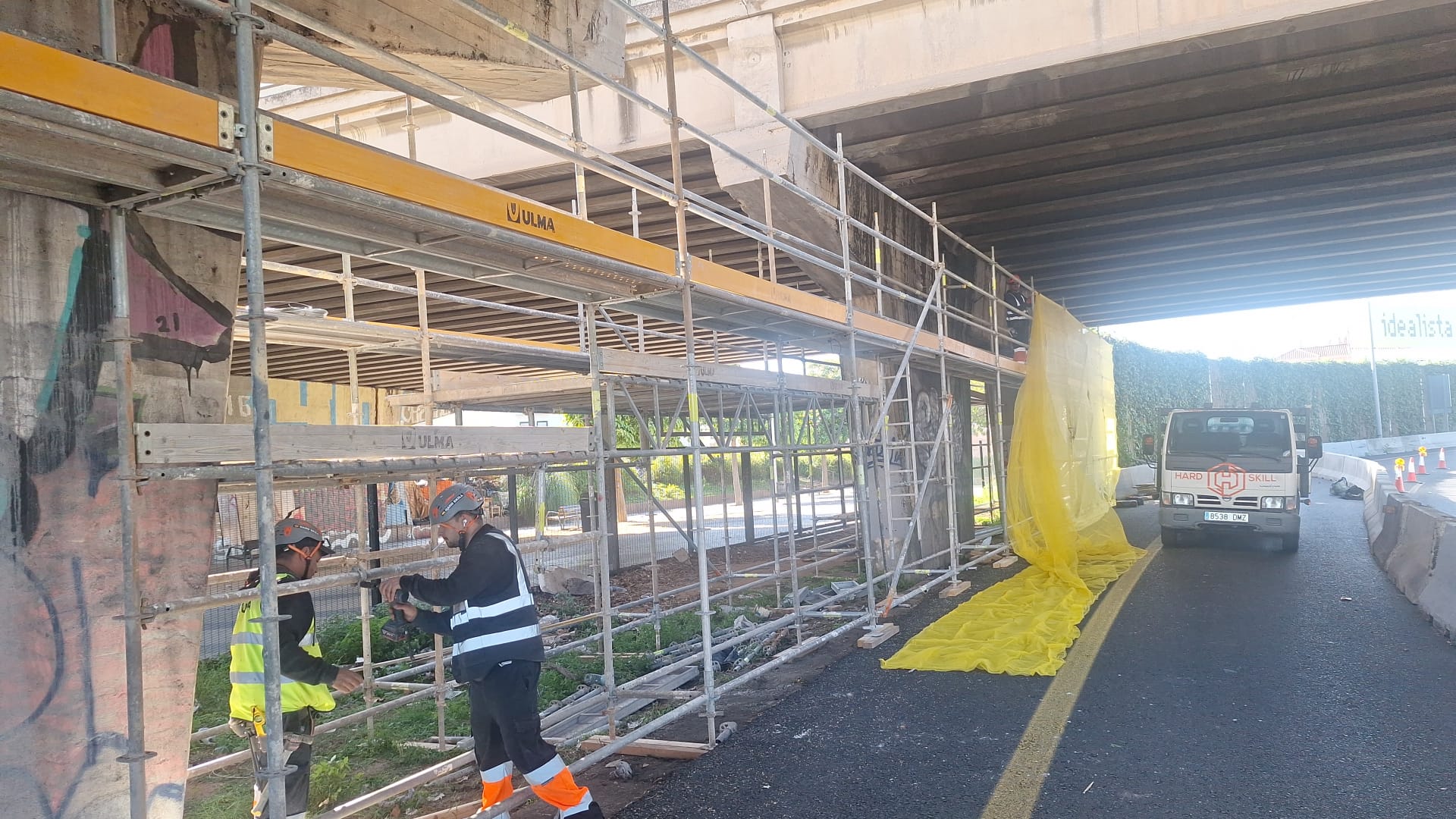 Operararios instalando los andamios para poder acomenter las obras de reparación en el punete de Jacint Verdaguer.